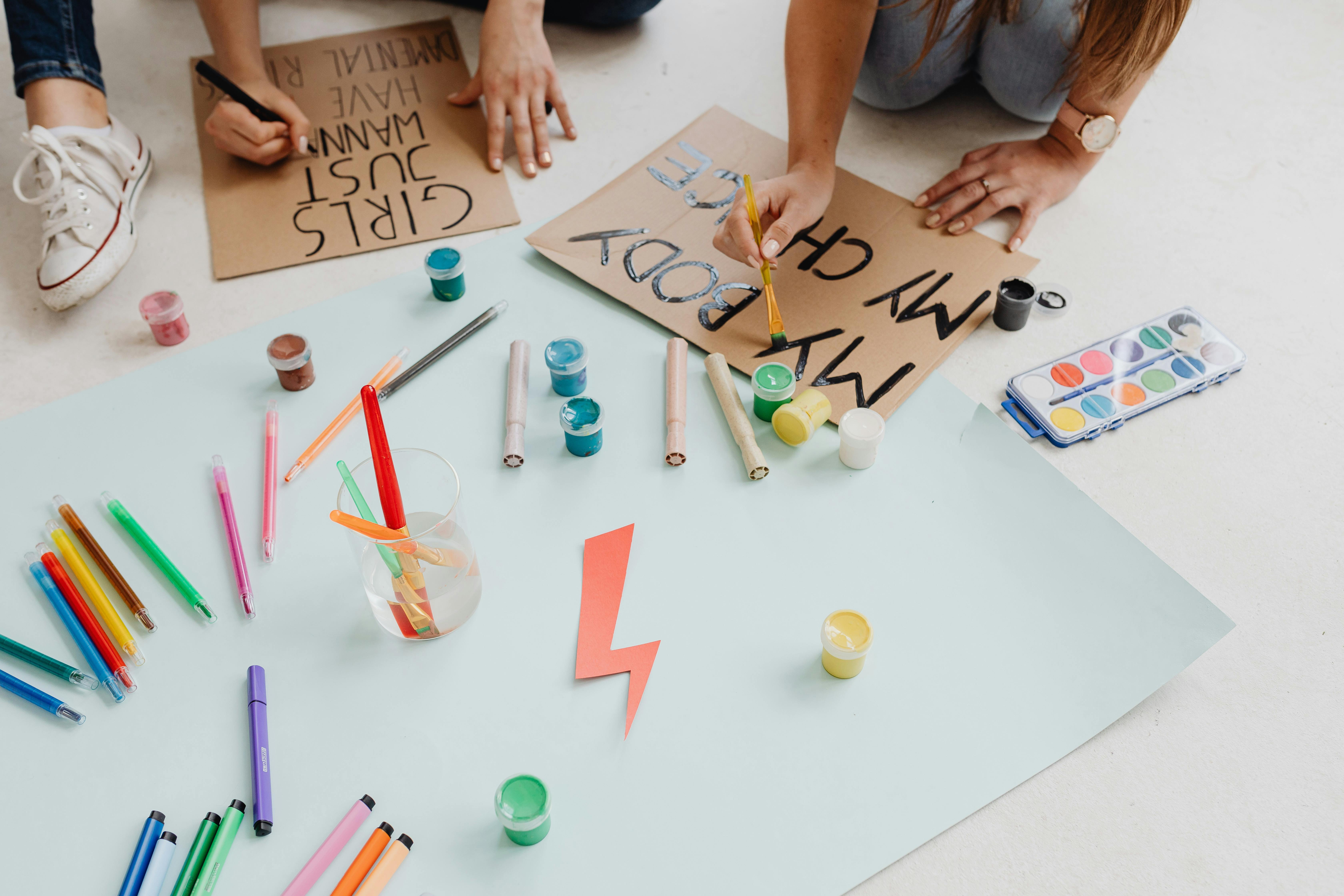 two women writing on cardboards