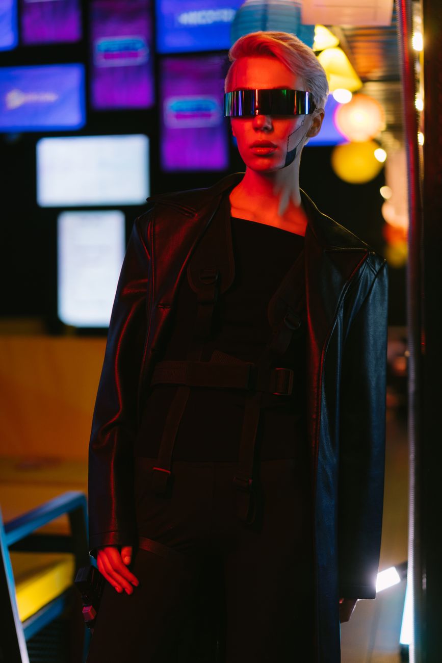 Stylish woman in cyberpunk attire with LED background lighting.