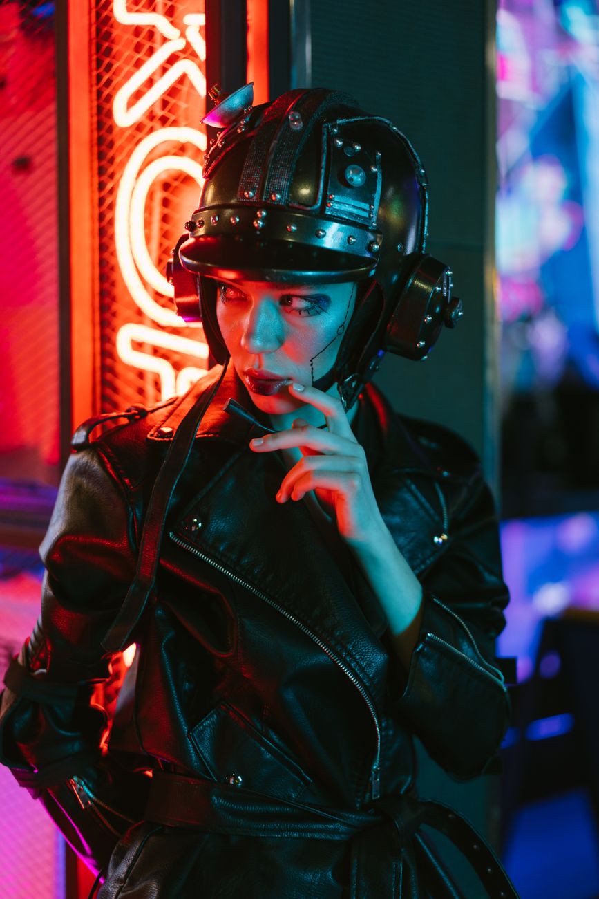 Stylish woman in cyberpunk outfit posing under neon lights.