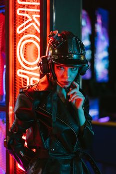 Woman in futuristic attire with neon lights in a cyberpunk style setting.
