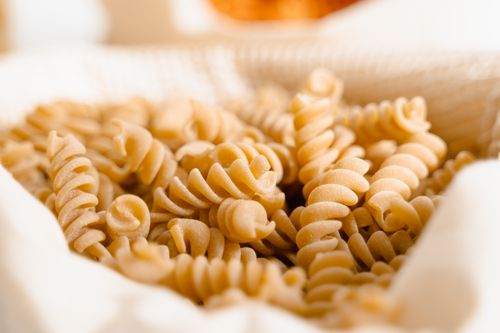 Free High-quality close-up of uncooked fusilli pasta in a basket, perfect for food photography. Stock Photo