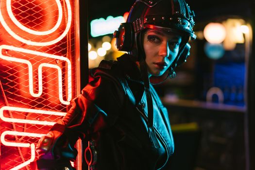 A futuristic fashion portrait featuring a woman in cyberpunk style illuminated by neon lights.