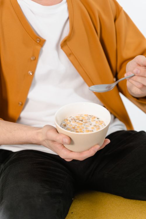 Person Holding a Spoon and Ceramic Bowl · Free Stock Photo