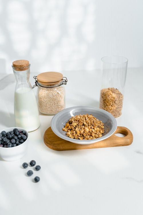 Free Delicious granola, blueberries, and milk setup on a light kitchen countertop. Stock Photo