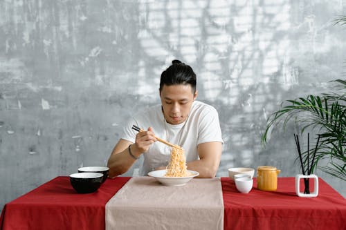 Man Eating Noodles Using Chopsticks