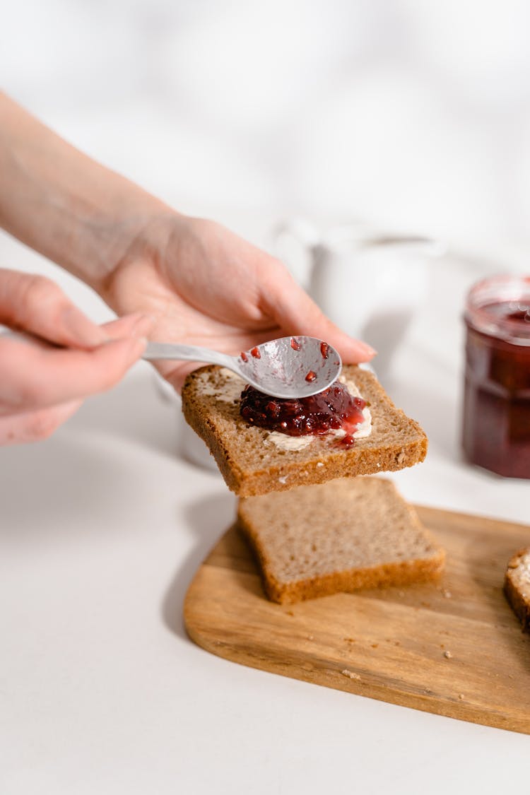 CLose-Up Shot Of A Person Making A Sandwich