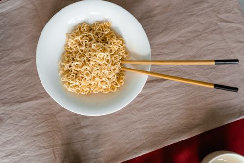 Free Flat lay of ramen noodles in a white bowl with chopsticks, ready to eat. Stock Photo