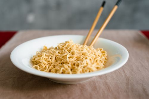Free Close-up of plain noodles served in a bowl with chopsticks on a neutral background. Stock Photo