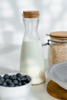 A stylish breakfast scene featuring milk, blueberries, and oatmeal in a sunny kitchen.