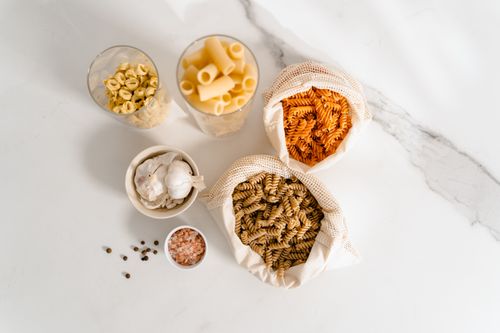 Free Top view of various uncooked pasta with spices on a marble surface, highlighting culinary essentials. Stock Photo