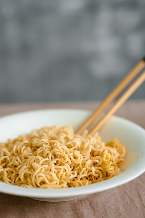 Free A close-up view of cooked noodles in a bowl with chopsticks, perfect for culinary use. Stock Photo