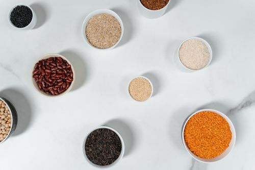 Free Top view of various grains and legumes in bowls on a white marble surface. Stock Photo