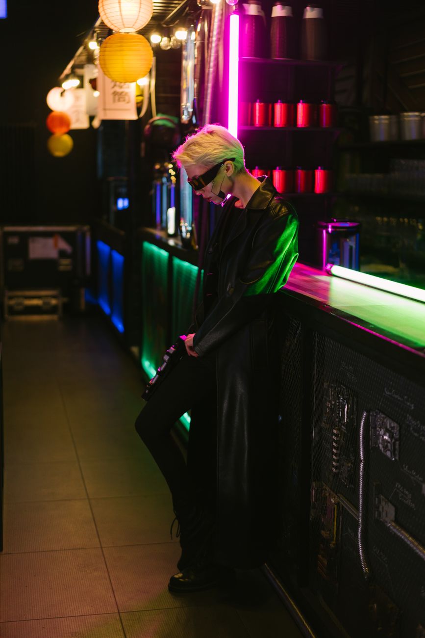 A stylish individual in a cyberpunk setting with neon lights and futuristic fashion.