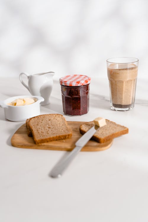 Free Bread with Butter and Glass of Chocolate Milk on Table Stock Photo