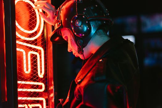 A woman in cyberpunk attire stands by vibrant neon lights, creating a futuristic scene.