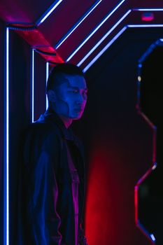 A man stands in a futuristic setting illuminated by neon lights in a cyberpunk style.