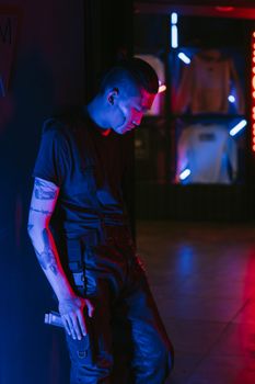 Stylish young man in cyberpunk attire, illuminated by vibrant neon lights.. stylish, young, cyberpunk
