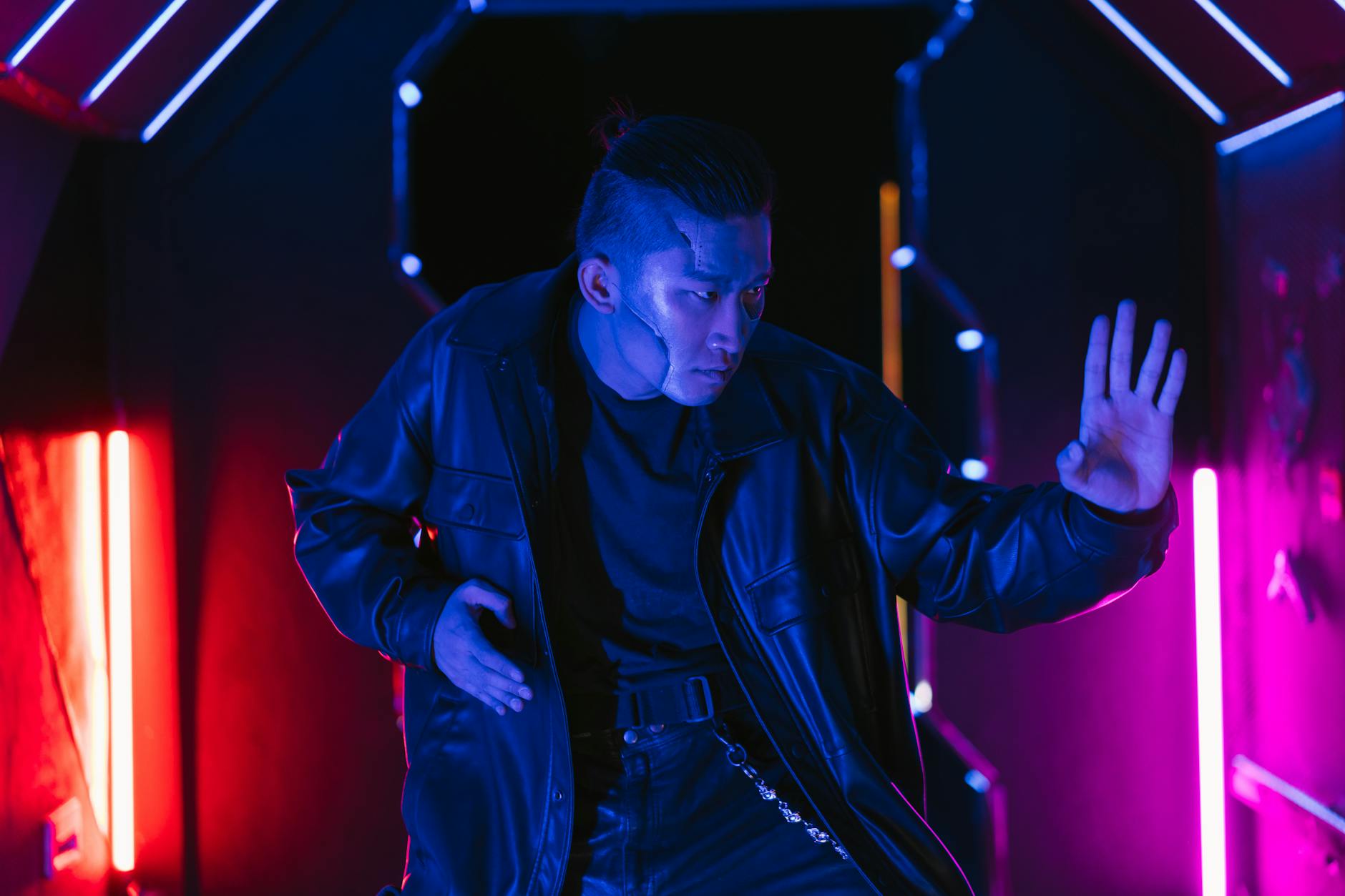 An Asian man in cyberpunk style poses against neon lights, conveying a futuristic vibe.