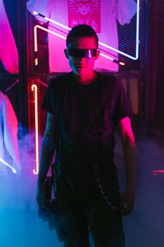 Man in futuristic attire poses with neon lights and fog, embodying cyberpunk style.
