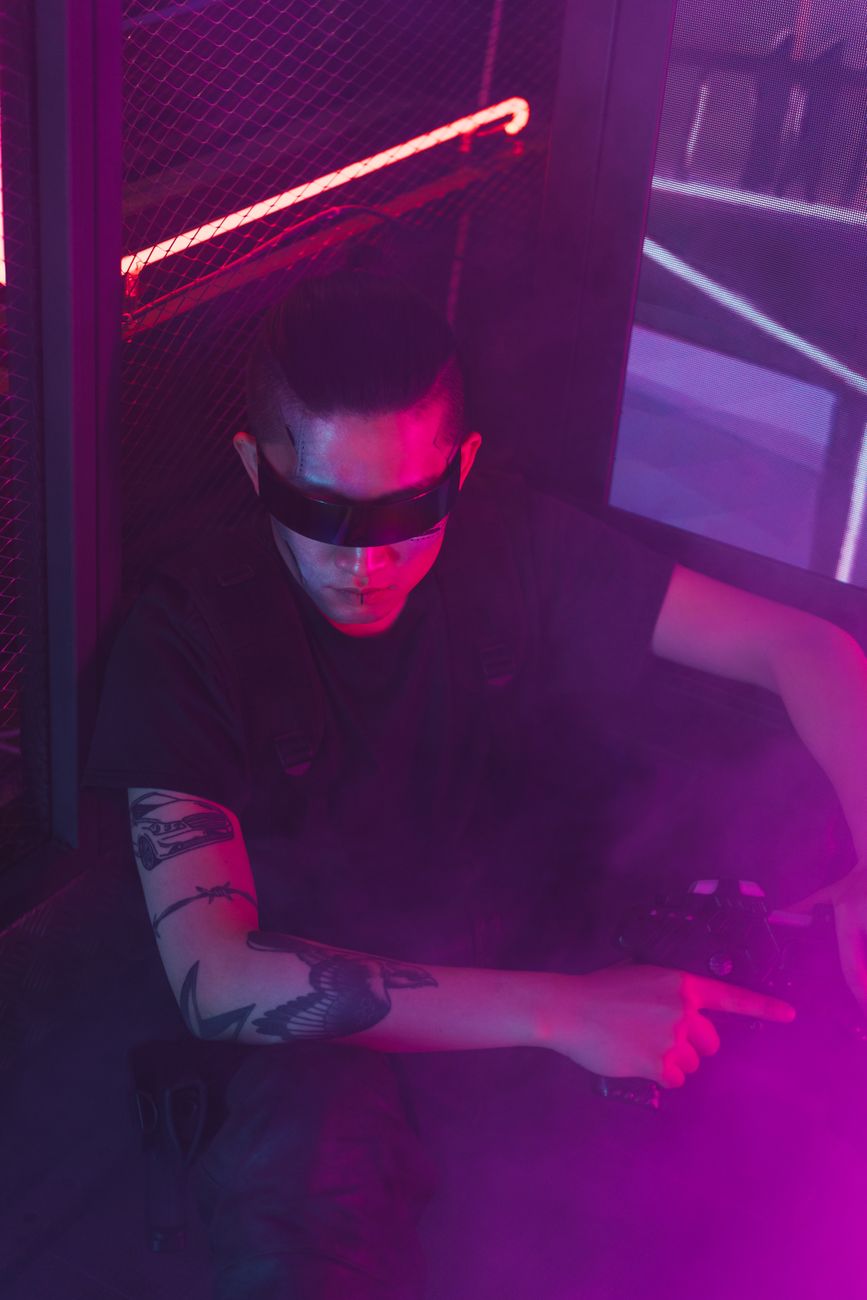 Stylish cyberpunk portrait of a man in neon lights wearing sunglasses.