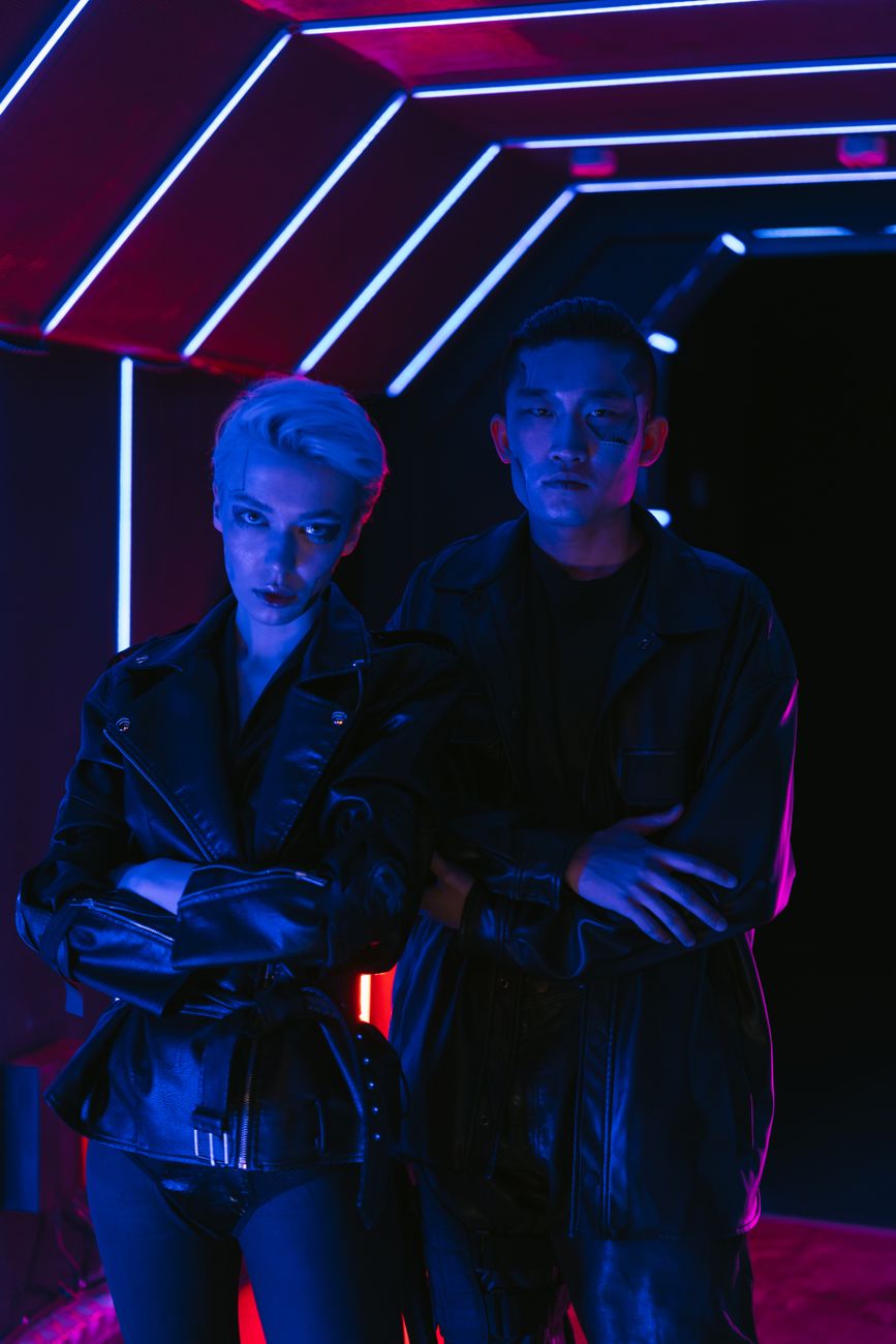 Two models in cyberpunk style with neon lights, capturing a futuristic fashion theme.