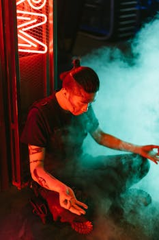A man meditates in a futuristic cyberpunk setting with neon lights and smoke.