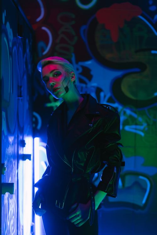 Figure against a graffiti wall in green neon — photo by Mikhail Nilov on Pexels