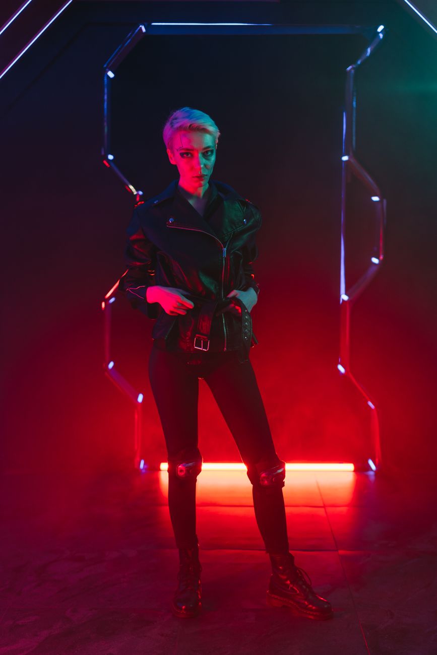 Stylish woman in neon-lit cyberpunk setting wearing leather jacket.