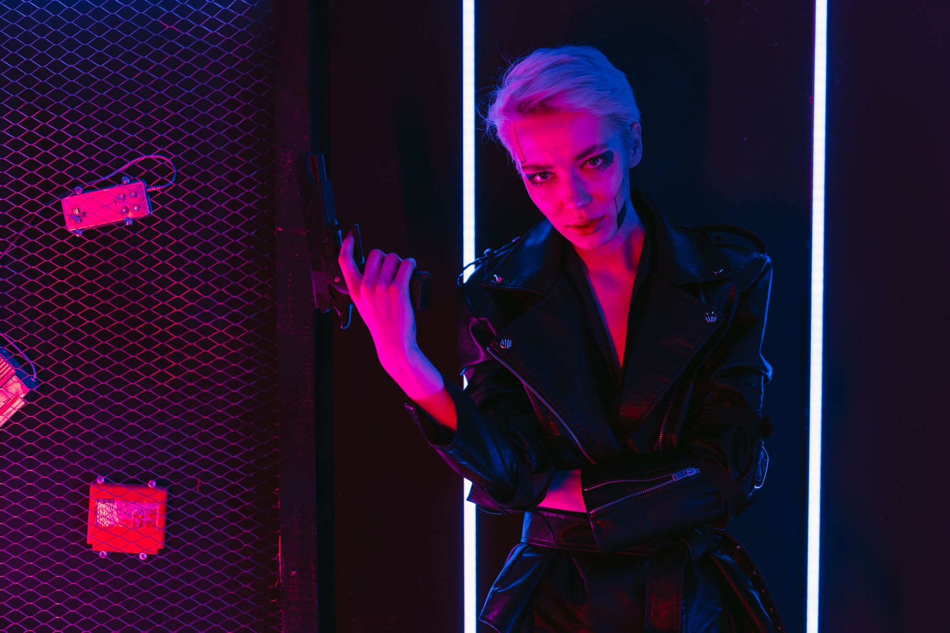 Edgy cyberpunk woman with pistol bathed in neon lights, futuristic style.