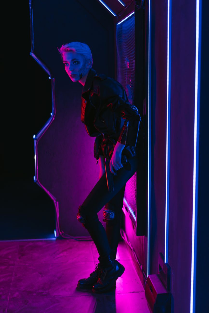 Stylish woman in cyberpunk outfit illuminated by vibrant neon lights.. stylish, woman, cyberpunk