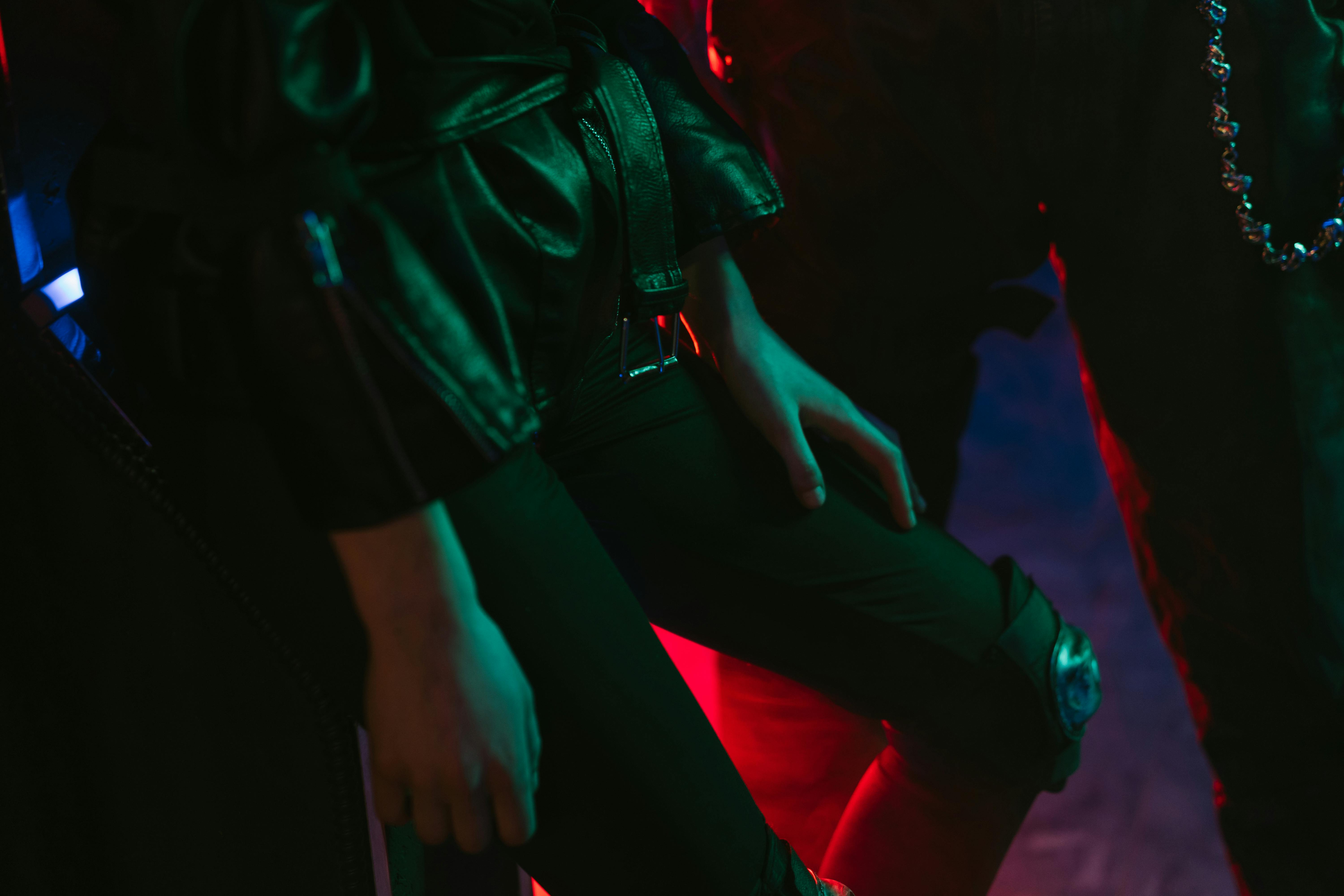 Stylish fashion shot with neon lighting and leather attire, highlighting cyberpunk aesthetics.