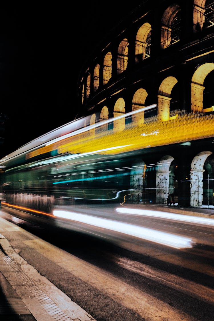 Fast Bus Driving On Road Against Coliseum In Night City