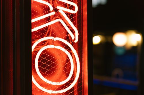 Free Close-up of a glowing red neon sign in the nighttime cityscape. Stock Photo