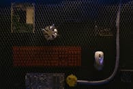 Computer Parts on a Black Surface Behind Wire Mesh