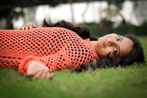 Free Photo Woman in Orange Long-sleeved Shirt Laying on Lawn Stock Photo