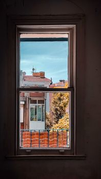 Charming view of colorful buildings through a classic window frame, showcasing urban architecture.