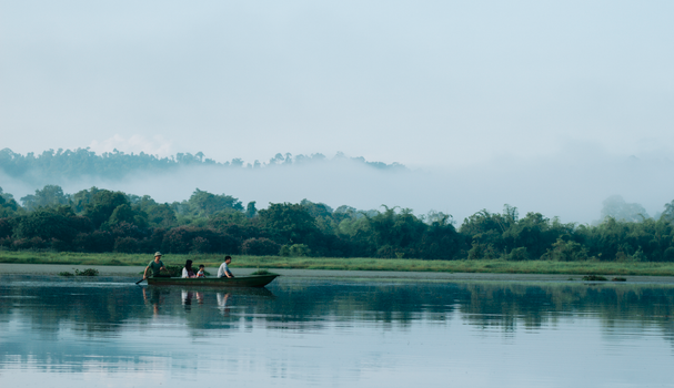 A peaceful boat ride with a family on a misty lake surrounded by lush greenery in Vietnam.