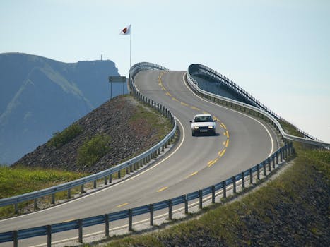 一辆汽车行驶在标志性的大西洋公路上，沿途可欣赏海岸景观和蜿蜒的建筑