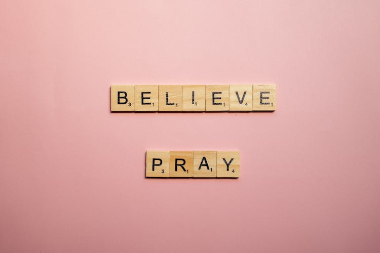 A Believe And Pray Words Of Encouragement  On Pink Surface