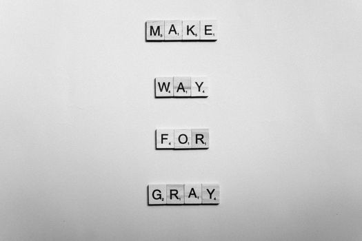 Black and white word art using tile letters forming 'Make way for gray' on a textured surface.