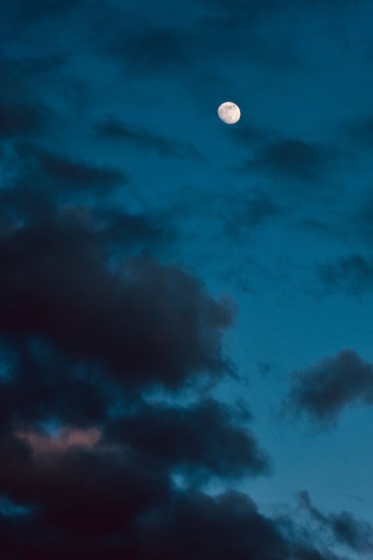 Moon Shining Through Dark Sky In Evening