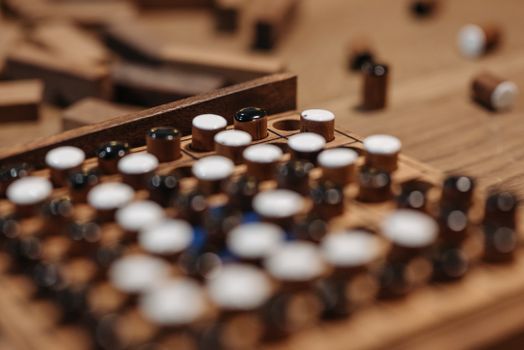 Intricate wooden board game with strategic pieces on a wooden table, captured close-up.