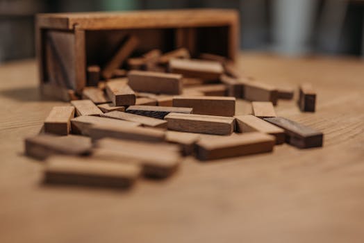 Close-up of wooden Jenga blocks scattered on a wooden surface, evoking nostalgia and playfulness.
