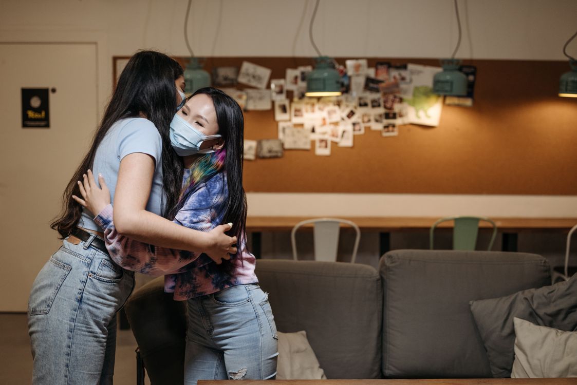 Friends in Masks Hugging · Free Stock Photo