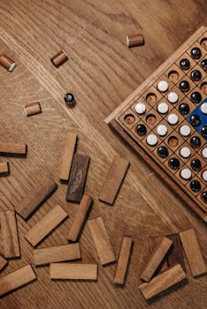 Wooden board game with pieces and blocks on a wooden table, ready for play.