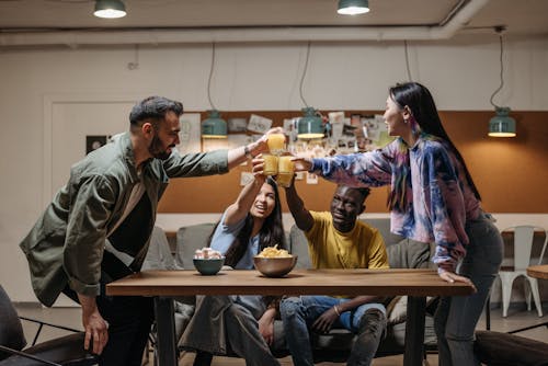 Free A Group of Friends Toasting Drinks while Having Conversation Stock Photo