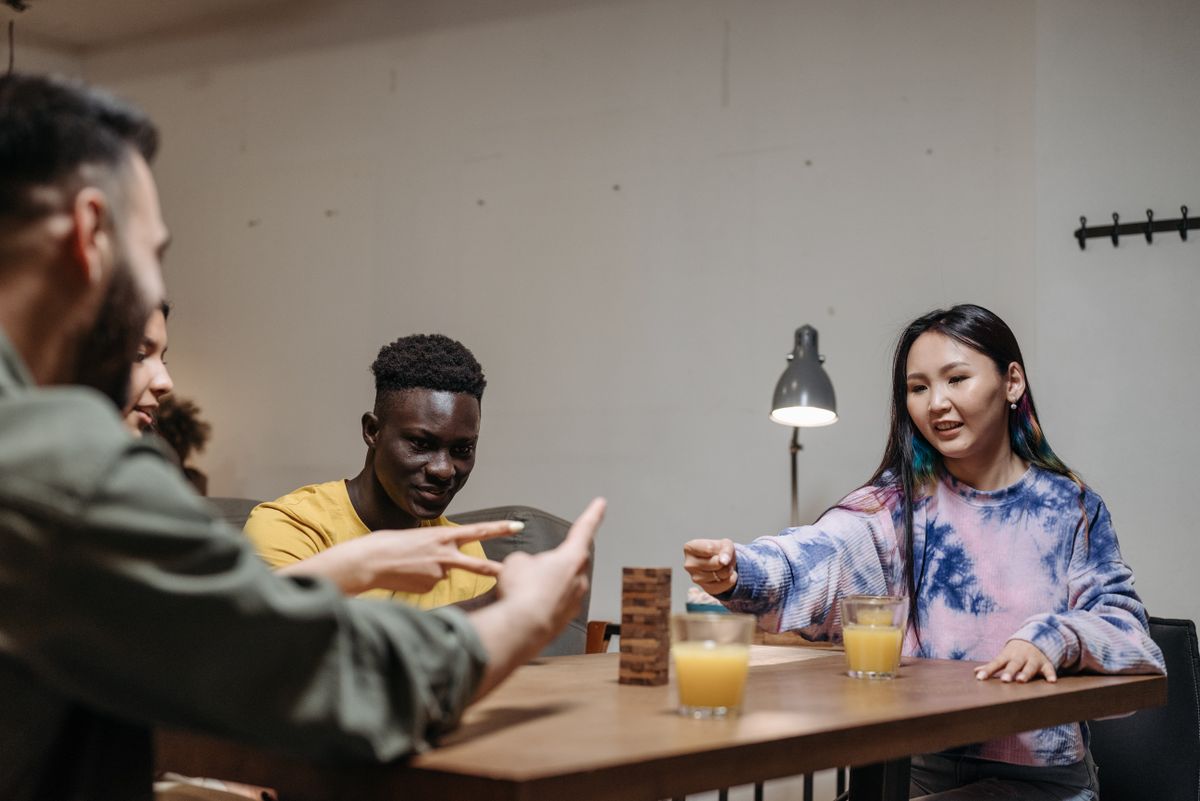 Adults gathered around a table enjoying a strategy game