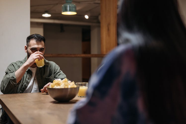 Man Drinking Juice At A Table