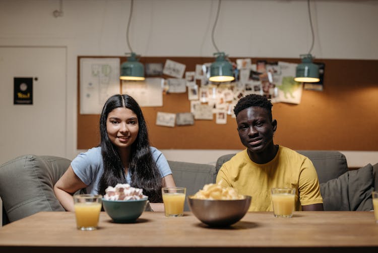 Smiling Couple Sitting By Table