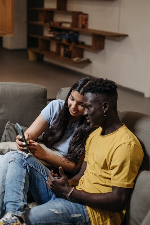 Couple Sitting with Smartphone on Couch